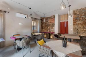 a restaurant with tables and chairs and a brick wall at Decanter House in Borgomanero