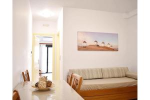 a living room with a table and a couch at Manolika Studio 5 in Kithnos +2 photos