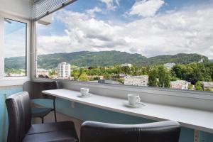 a room with a table and chairs and a large window at Ferienwohnung am Bodensee in Bregenz