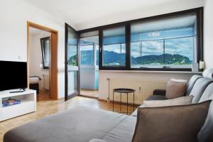 a living room with a couch and some windows at Ferienwohnung am Bodensee in Bregenz