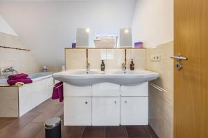 a bathroom with a white sink and a tub at To Huus am Steinhuder Meer in Steinhude +30 photos