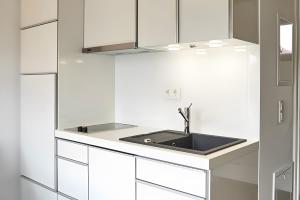 a kitchen with white cabinets and a sink at Charmingsuite in Bad Teinach-Zavelstein +8 photos