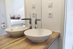 a bathroom with a white bowl sink on a wooden counter at Charmingsuite in Bad Teinach-Zavelstein