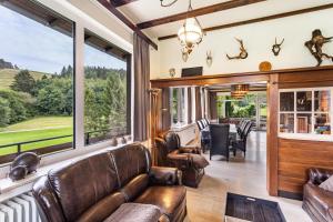 a living room with leather furniture and a large window at Zum Holzknecht in Willingen