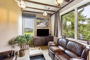 a living room with leather furniture and a flat screen tv at Zum Holzknecht in Willingen