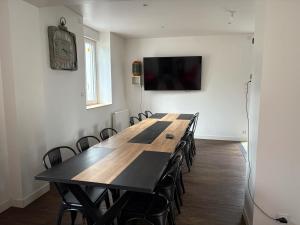a conference room with a long table and chairs at Maison de vacances avec piscine in Messeix
