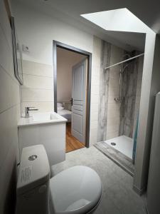 a bathroom with a toilet and a sink and a tub at Maison de vacances avec piscine in Messeix +9 photos