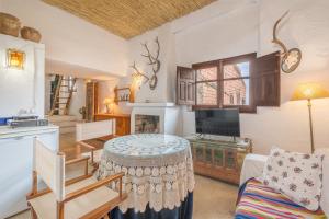 a living room with a table and a kitchen at Buhardilla La Prensa in Sorvilán +23 photos