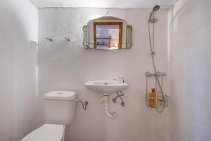 a bathroom with a toilet and a sink and a mirror at Buhardilla La Prensa in Sorvilán