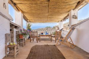 a porch with a table and chairs and a view of the ocean at Buhardilla La Prensa in Sorvilán