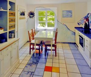 a kitchen with a table and chairs and a window at Ferienwohnung Mulleby in Süderhackstedt