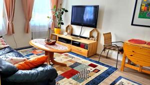 a living room with a table and a tv at Ferienwohnung Wyss - Wolfach in Untertal