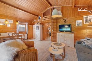 ein Wohnzimmer mit Sofa und Fernseher in der Unterkunft Moi Holzhaisel in Elmstein