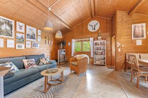 ein Wohnzimmer mit einem blauen Sofa und einem Tisch in der Unterkunft Moi Holzhaisel in Elmstein