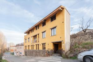 a yellow building with windows on a street at La Posada in Chera