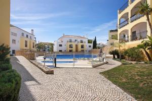 a house with a swimming pool next to a building at O'pomar 150 in Tavira