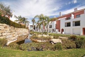 a retaining wall and a pond in front of a building at O'pomar 150 in Tavira