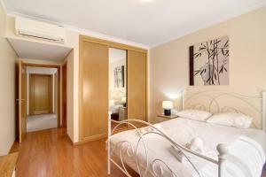 a bedroom with a bed with a white bedspread at O'pomar 150 in Tavira +13 photos
