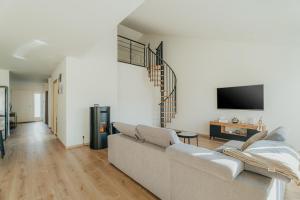 a living room with a couch and a tv at Maison avec jardin proche Dinan in Trévron