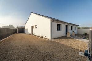 a white house with a gravel driveway at Maison avec jardin proche Dinan in Trévron