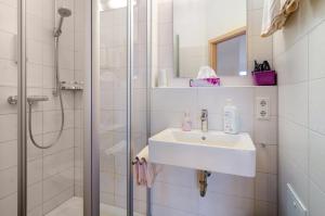 a white bathroom with a sink and a shower at Pension Zum Talhof in Reichenau +61 photos