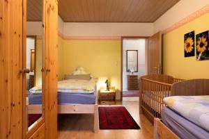 a bedroom with two beds and a crib at Fewo Kaiser in Südbrookmerland