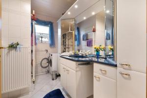 a bathroom with a sink and a mirror at Fewo Kaiser in Südbrookmerland +20 photos