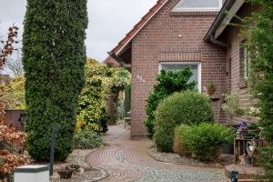 a brick house with a brick walkway at Fewo Kaiser in Südbrookmerland