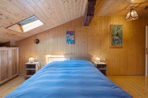 a bedroom with a blue bed in a wooden wall at Casa della Rosina in Bresimo