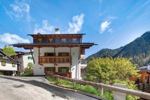 a house with a balcony on the side of a road at Appartamenti Camilla in Canazei