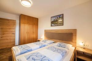 a bedroom with two beds and a wooden headboard at Parigger Apt Enzian in Racines