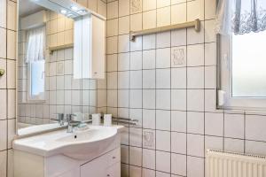 a white bathroom with a sink and a mirror at Ferienwohnung bei Will in Stützerbach +16 photos
