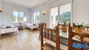 a living room with two beds and windows at Costacabana - Villa Pilar in Lloret de Mar