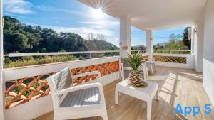 a balcony with white chairs and a vase on it at Costacabana - Villa Pilar in Lloret de Mar