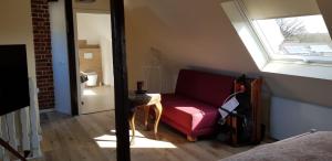 a living room with a red couch and a window at Maisonette-Wohnung in Gladbeck in Gladbeck