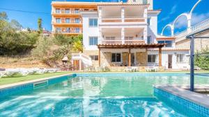 a villa with a swimming pool in front of a building at Costacabana - Villa Pilar in Lloret de Mar