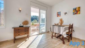 a room with a piano and a table and a sliding glass door at Costacabana - Villa Pilar in Lloret de Mar