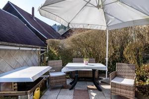 a table and chairs with an umbrella on a patio at Ferienwohnung bei Will in Stützerbach