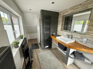 a bathroom with a sink and a mirror at Ferienhaus Neeborg in Zetel +18 photos
