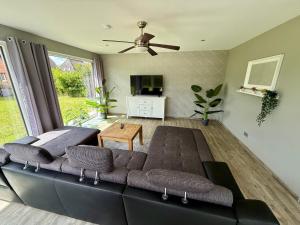 a living room with a couch and a tv at Ferienhaus Neeborg in Zetel