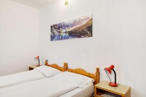 una camera da letto con un letto e un quadro sulla parete di Albergo Trieste - Lorenzago a Lorenzago