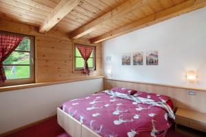 a bedroom with a bed in a wooden cabin at Appartamenti Camilla in Canazei