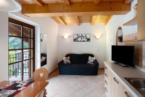 a living room with a couch and a tv at Appartamenti Camilla in Canazei