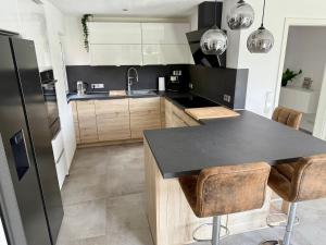 a kitchen with a black counter top and wooden cabinets at Ferienhaus Neeborg in Zetel