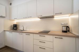 a kitchen with white cabinets and a sink at Ferienwohnung Hirzer Edelweiss in Avelengo