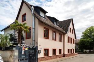 a white house with a black roof at Ferienwohnungen Eulenspiegel in Breisach am Rhein