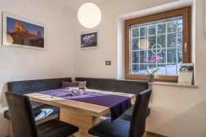 a dining room table and chairs with a purple table cloth at Ferienwohnung Hirzer Edelweiss in Avelengo