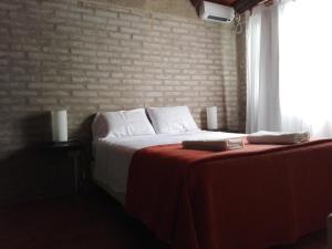 
a white bed sitting in a room next to a window at Villa Carlos Paz Alojamiento Santa Ponsa in Villa Carlos Paz
