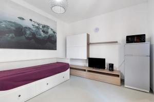 a bedroom with a large bed with a purple blanket at La Pelusa Peschiera in Peschiera del Garda