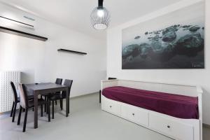 a bedroom with a bed and a table and chairs at La Pelusa Peschiera in Peschiera del Garda +17 photos